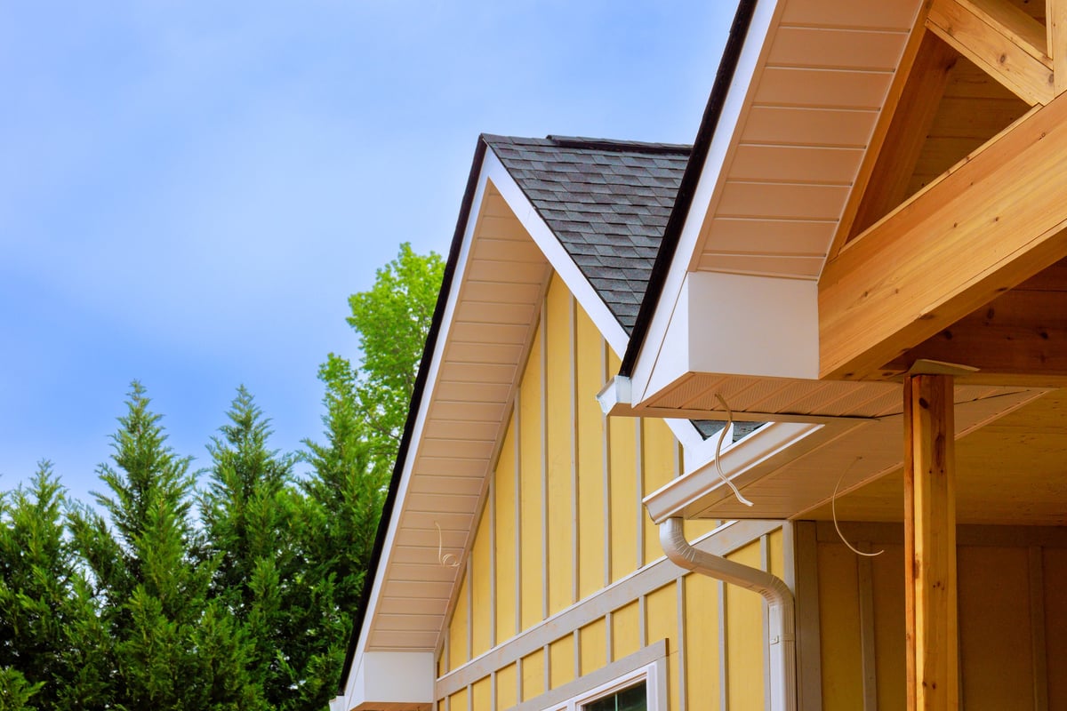 New yellow house its roof sides with edges gutters under construction process