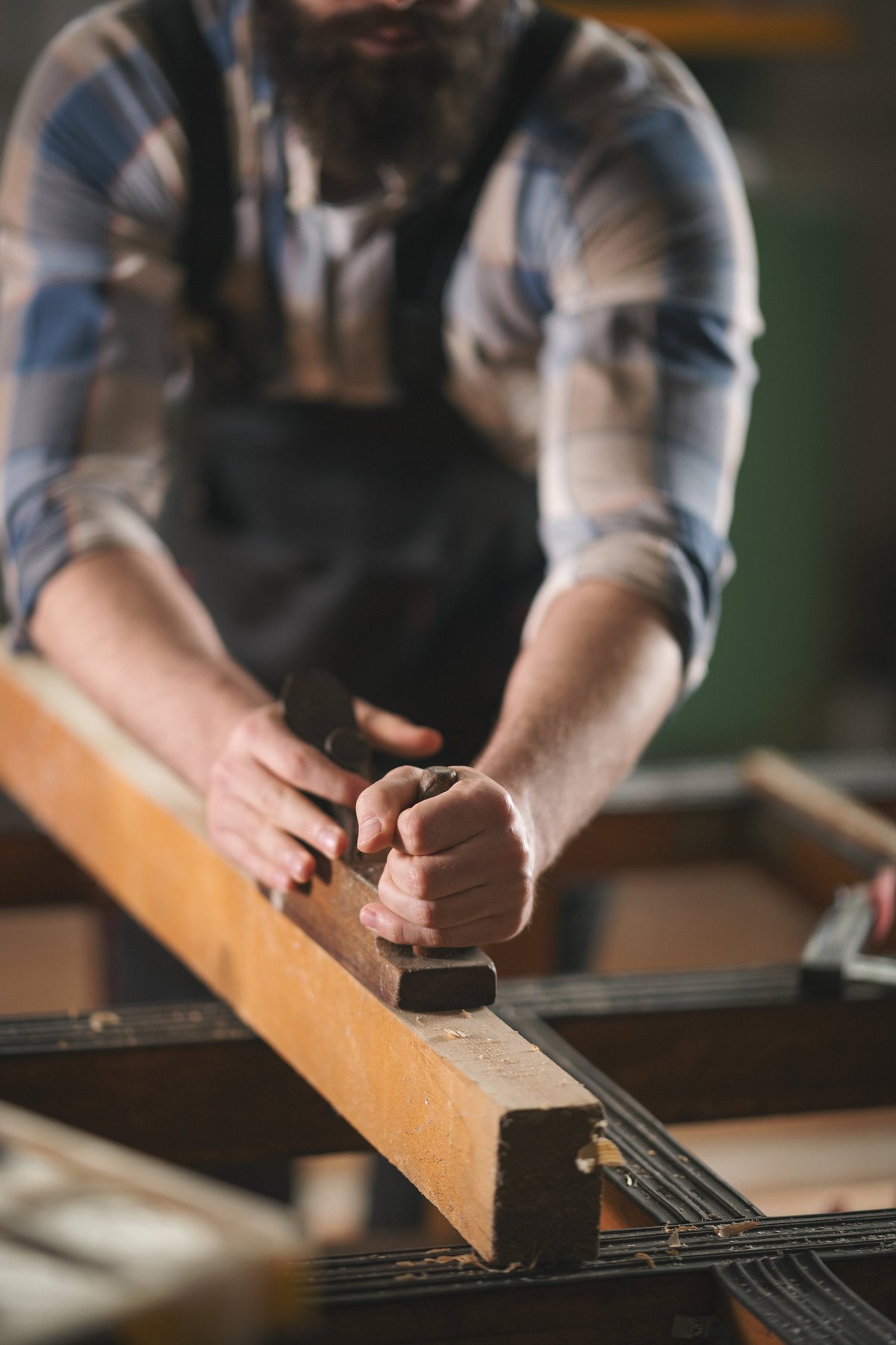 Young carpenter working with wood in a workshop